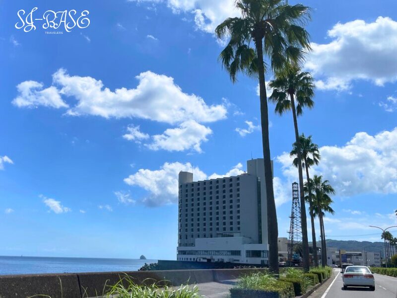 伊東の海沿いに建つホテルサンハトヤと青空の風景