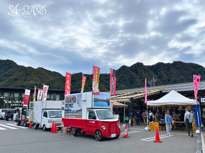 道の駅八ッ場ふるさと館の正面に並ぶキッチンカーと多くの人で賑わう様子