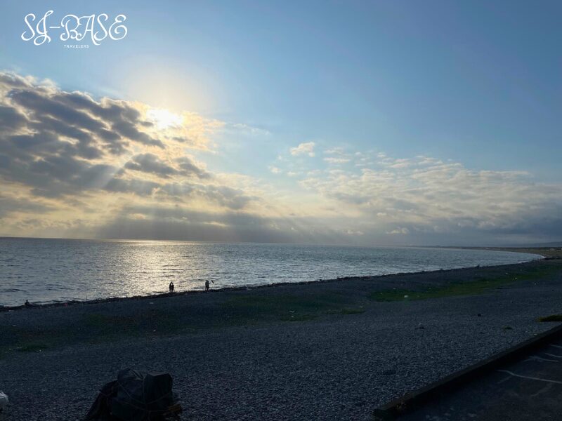 夕方の千本浜海岸。西日が差し込み、静かな海に光が反射して幻想的な風景。