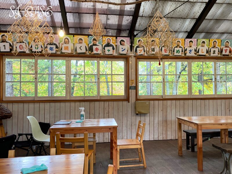 アサマヒュッテのイートインスペース。木のテーブルと窓辺の景色が心地よい明るい空間。