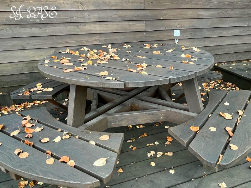 落ち葉に包まれたアサマヒュッテ前のベンチとテーブル