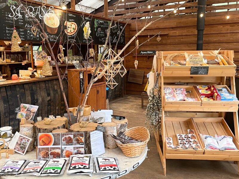 アサマヒュッテの売店スペース。木製の棚やディスプレイにキャンプグッズや食品が並ぶ。