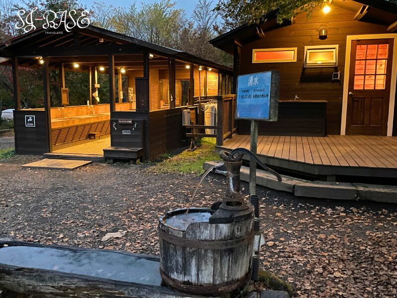 スウィートグラスの炊事場と湧水ポンプ。夜の灯りに照らされる共有スペース。