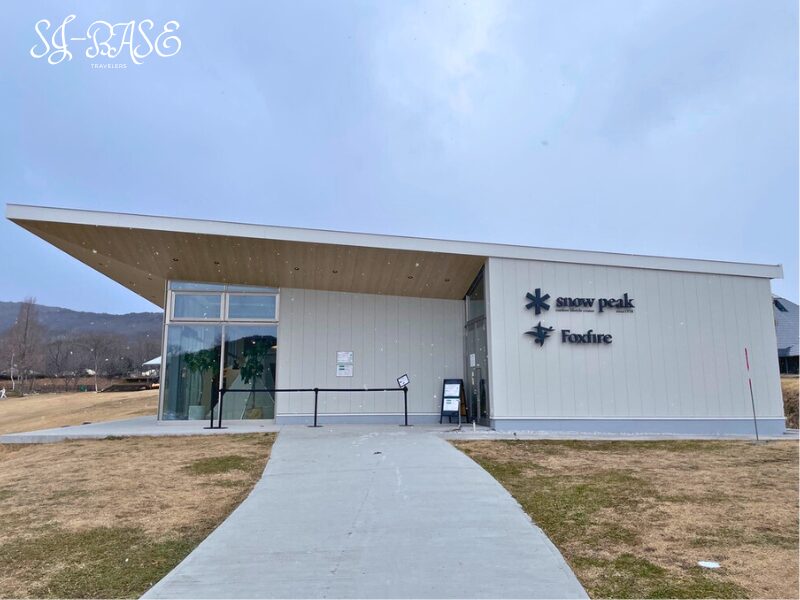 スノーピーク白河高原のセンターハウス外観。Snow PeakとFoxfireのロゴが並ぶ建物