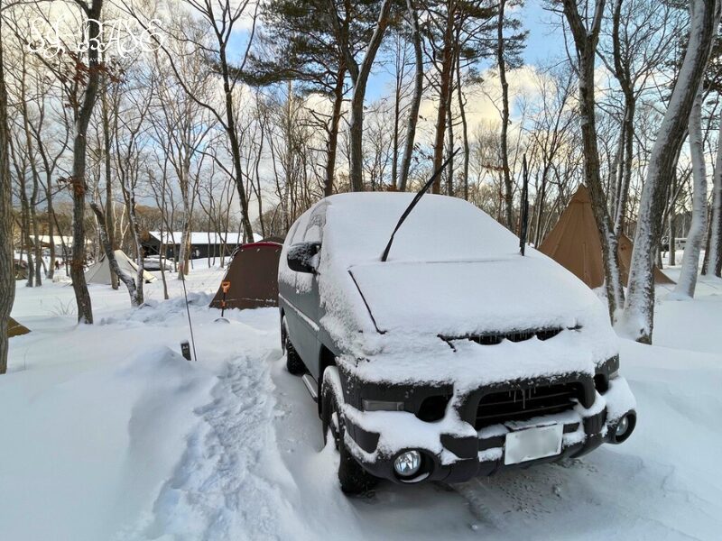 スノーピーク白河高原での冬キャンプの様子。テントや車に雪が積もり、サイト全体が雪に覆われた雪中キャンプ