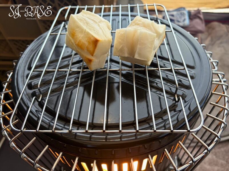 冬キャンプでストーブの上でお餅を焼いている様子